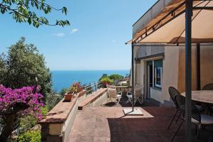 eine Terrasse mit einem Tisch, Stühlen und Meerblick in der Unterkunft Villa Roberta in Arenzano