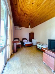 a room with two beds and a flat screen tv at Hotel "Qeti" in Shekhvetili