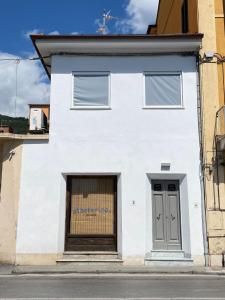 a white building with a door on a street at Sogni d'artista in Pietrasanta