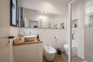 a white bathroom with a sink and a toilet at Santo Stefano Apartment with private Garden in Bologna