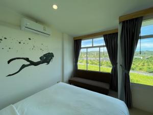 Rúm í herbergi á Dwell Phuket Airport Hotel at Naiyang