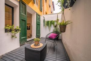 Santo Stefano Apartment with private Garden في بولونيا: فناء مع كرسيين وطاولة بالنباتات