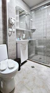 a bathroom with a shower and a toilet and a sink at Sierra Hotel Tbilisi in Tbilisi City