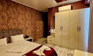 a bedroom with a bed and a large white cabinet at Sierra Hotel Tbilisi in Tbilisi City