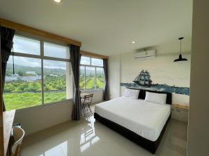 Rúm í herbergi á Dwell Phuket Airport Hotel at Naiyang
