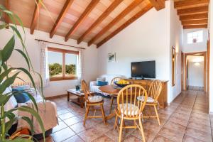 a living room with a table and chairs and a tv at Finca Can Petit - Apartamento rural in Capdepera