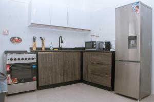 uma cozinha com um frigorífico e um fogão em Candide Guest House em Limbe
