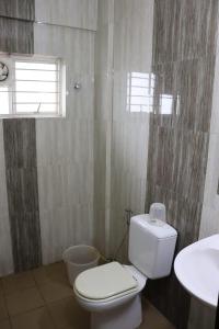 uma casa de banho com um WC e um lavatório em Uthradam towers em Trivandrum