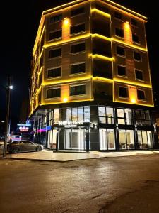 um edifício alto numa rua da cidade à noite em Moonlight Suite Hotel em Trabzon