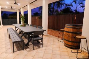 a patio with a table and a barrel at Top End Getaway - Luxury Home in Palmerston