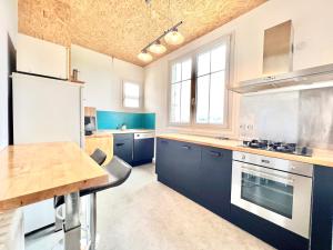 a kitchen with blue cabinets and a wooden table at Les hauts de tison ~ Vue sur la vallée du Clain in Poitiers