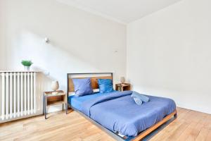 a bedroom with a large bed with blue sheets at Arc de Triomphe Superbe Appartement Paris in Paris
