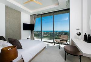 カタビーチにあるVilla Nordic Starのベッドと大きな窓が備わるホテルルームです。