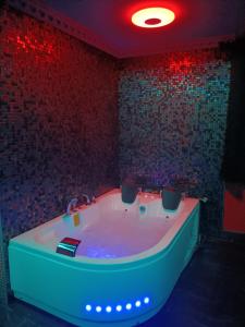 a bath tub in a room with red lights at L'instant romance Le Romantique in Castelnaudary