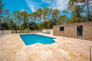 un patio con piscina y un edificio de ladrillo en Ma Case en Provence - Maison climatisée avec piscine, en Saint-Maximin-la-Sainte-Baume