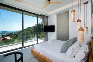 a bedroom with a bed and a large window at Villa Nordic Star Seaview Near Kata Beach in Kata Beach +48 photos