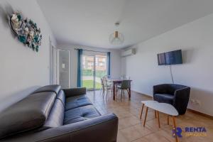 a living room with a couch and a table at La Perle WIFI Plain Pied Proche Mer in Saint Cyprien Plage