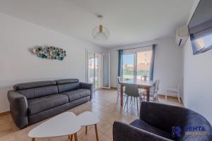 a living room with a couch and a table at La Perle WIFI Plain Pied Proche Mer in Saint Cyprien Plage