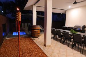 a room with a table and chairs and a candle at Top End Getaway - Luxury Home in Palmerston