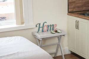 a small table with a sign on it next to a bed at Lotus Studio near Lanark in Carstairs
