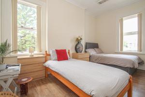 a bedroom with two beds and a desk and two windows at Lotus Studio near Lanark in Carstairs