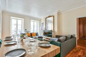 a dining room with a table and a couch at Arc de Triomphe Superbe Appartement Paris in Paris