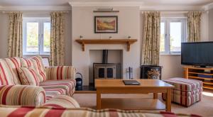 a living room with a couch and a fireplace at Cunsey Lodge in Far Sawrey