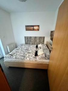 a bedroom with a large bed with a wooden headboard at MyMara, Apartmán Beťo in Bešeňová