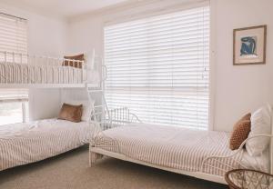 a bedroom with two bunk beds and a window at Sunny Corner Holiday Home in Crescent Head