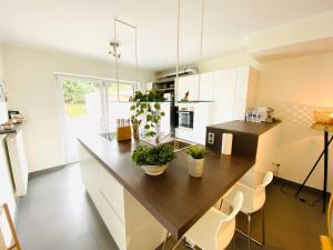 uma cozinha com armários brancos e um balcão de madeira em Large 3 bedrooms in Center with Terraces & Parking - ROL1 em Luxemburgo