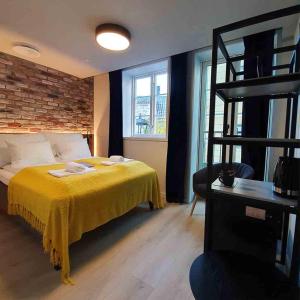 una camera da letto con un letto con copriletto giallo e una scala di Kragerø Hotell a Kragerø