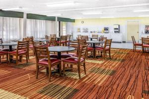 a dining room with tables and chairs and a kitchen at Days Inn & Suites by Wyndham Colonial in Williamsburg