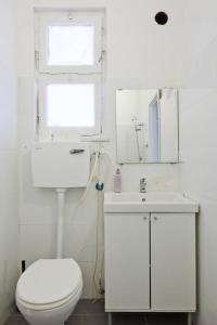 a bathroom with a toilet and a sink and a mirror at Florentine Studio in Tel Aviv