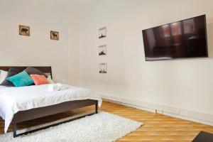 a bedroom with a bed and a flat screen tv on a wall at Florentine Studio in Tel Aviv