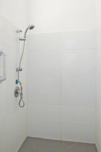 a shower in a bathroom with a white wall at Florentine Studio in Tel Aviv