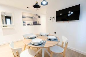 a dining room with a table and chairs and a tv at Apartamento Venecia Living Suites en Castellón in Castellón de la Plana