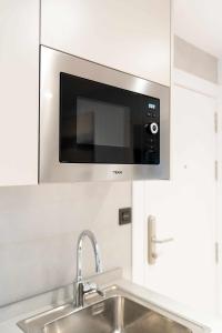 a microwave above a sink in a kitchen at Apartamento Venecia Living Suites en Castellón in Castellón de la Plana