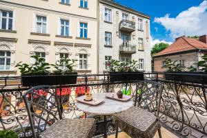 a table and chairs on a balcony with buildings at Salomea krakow apartments Bożego Ciała in Kraków