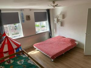 een slaapkamer met een bed en twee ramen. bij Sunnystay 43 in Middelburg