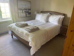 1 dormitorio con 1 cama con sábanas y almohadas blancas en Railway Cottage - Pet friendly with parking, en Ripon