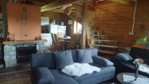 sala de estar con sofá azul y chimenea en Koliba Drabsko en Lom nad Rimavicou