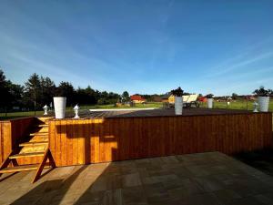 une clôture en bois avec une table en bois sur la terrasse dans l'établissement Domek letniskowy Jawor z basenem, à Małdyty