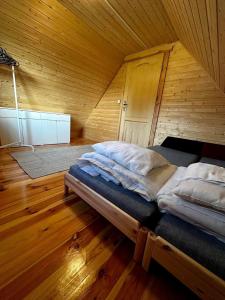 a large bed in a room with a wooden ceiling at Domek letniskowy Jawor z basenem in Małdyty