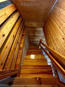 a staircase in a log cabin with wooden ceilings at Domek letniskowy Jawor z basenem in Małdyty