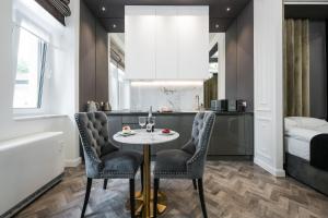 a room with a table and chairs and a bed at Salomea krakow apartments Bożego Ciała in Kraków