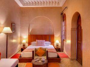 Marrakech Riads, Angsana Heritage Collection في مراكش: غرفة نوم مع سرير كبير مع ممر