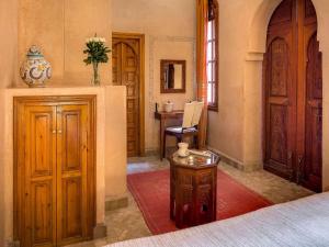 Marrakech Riads, Angsana Heritage Collection في مراكش: غرفة نوم بسرير وطاولة في غرفة