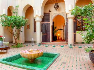 einen Innenhof mit einem Brunnen in der Mitte eines Gebäudes in der Unterkunft Marrakech Riads, Angsana Heritage Collection in Marrakesch