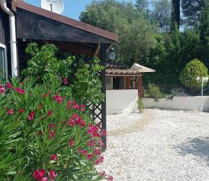 勒穆伊的住宿－HOME Ste Maxime，一座花园,在一座建筑前方种有粉红色花卉