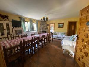 sala de estar con mesa, sillas y perro en El Magnolio, en Santa Cruz de Pinares